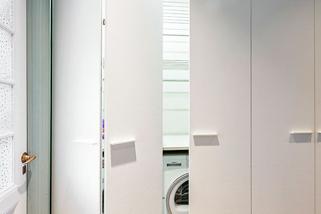 Förvaringslösning i vitt, med öppen dörr med tvättmaskin bakom