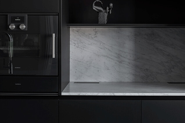 elegant kök i marmor och svarta köksluckor