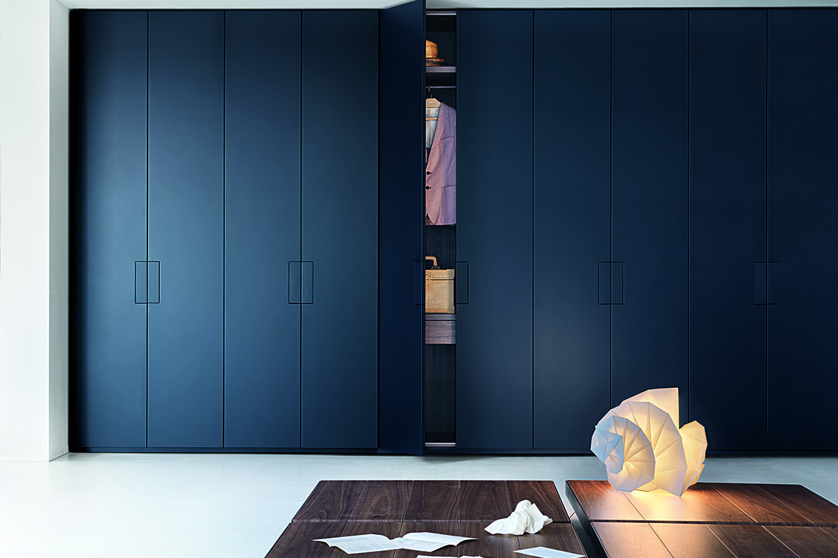 Exklusiv garderob i mörk färg med en halvöppen dörr, från Lema.