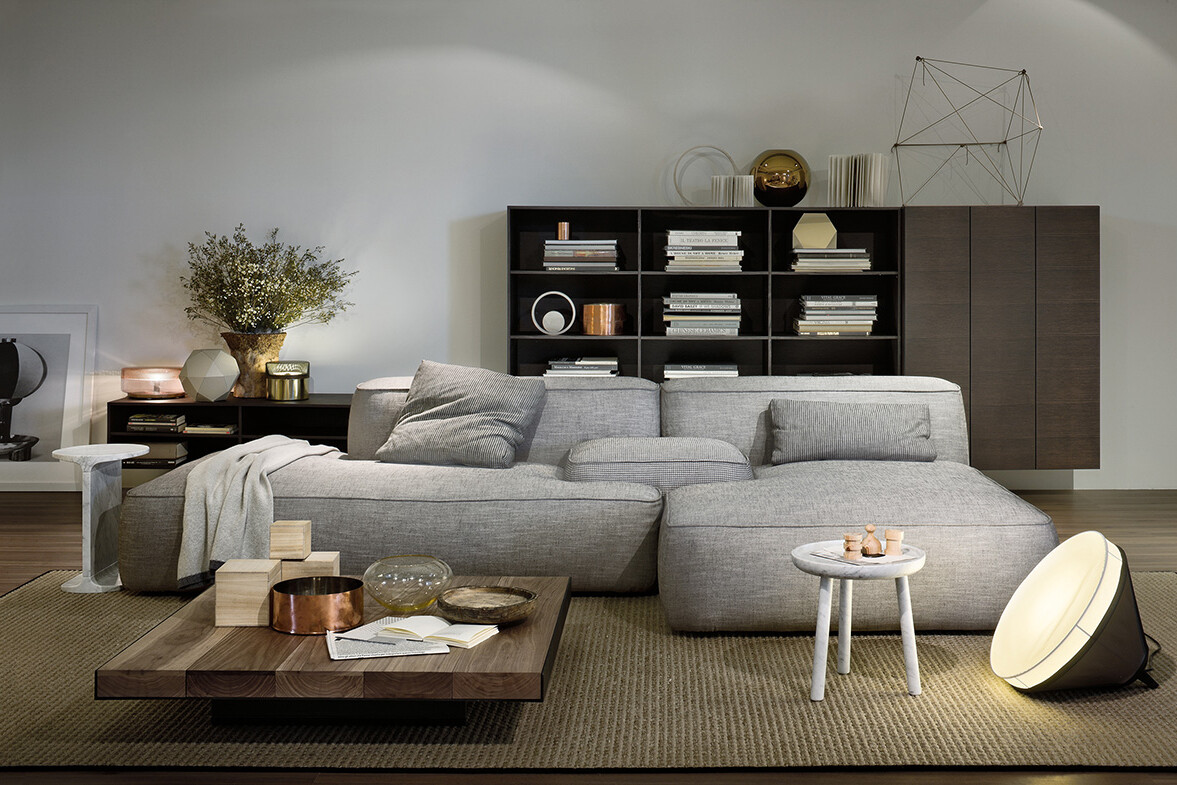 exklusiv grå soffa, soffbord, matta, golvlampa och inredning