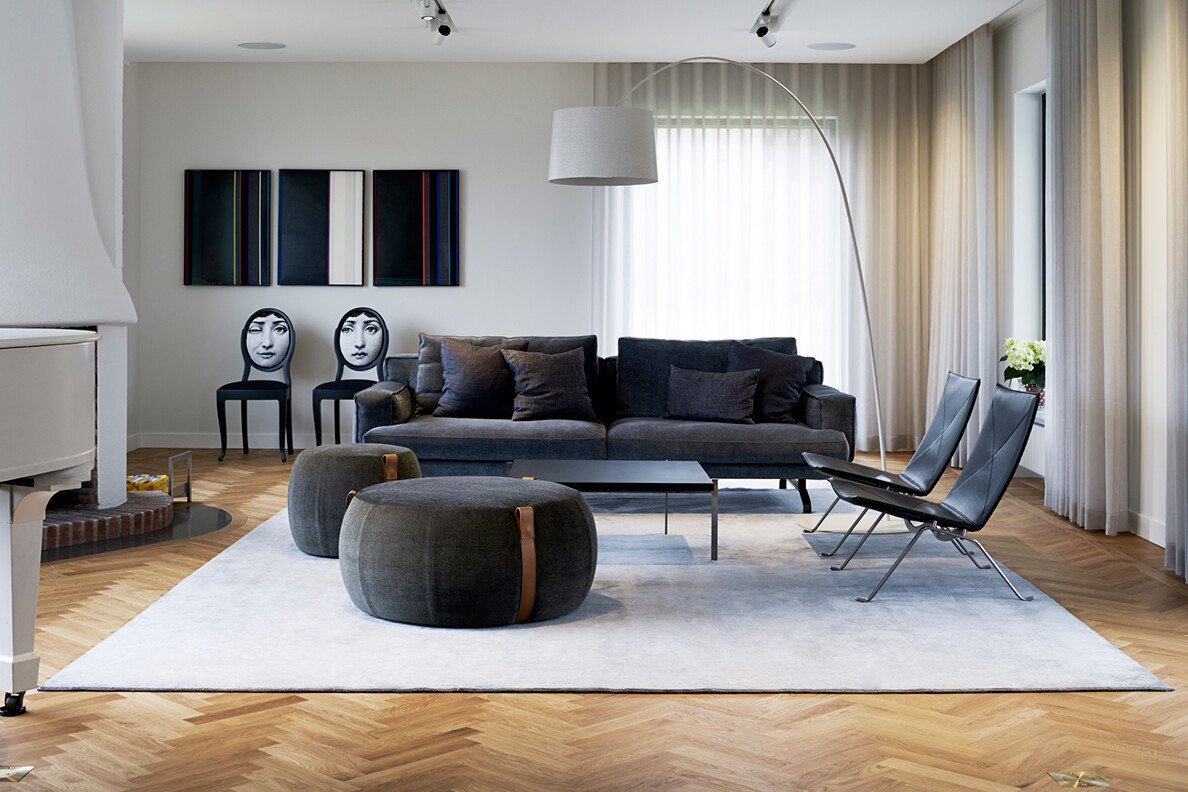 elegant vardagsrum med mörkgrå soffa och sittpuffar från Lema.