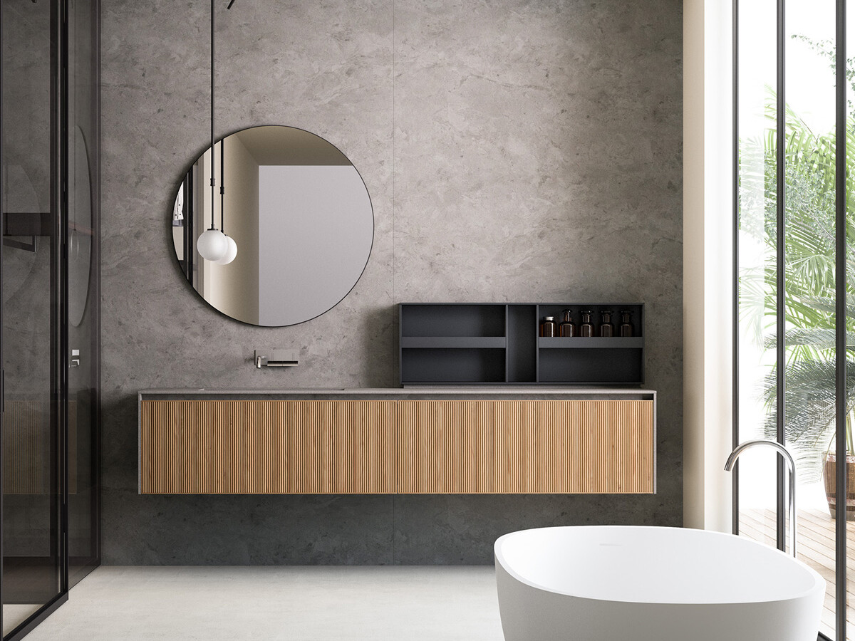 Minimalistiskt badrum med badkar, en rund spegel och handfat